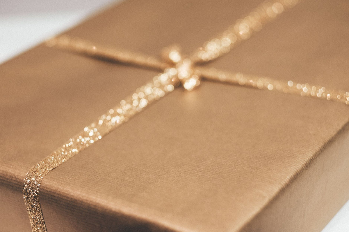 Luxurious gold gift box with glittering ribbon, perfect for weddings and special occasions.