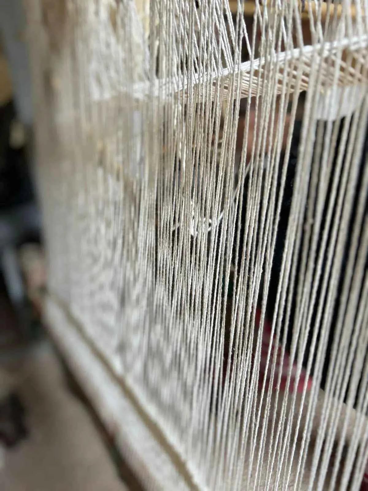 Gros plan sur les fils de chaîne du métier à tisser d'un tapis berbère