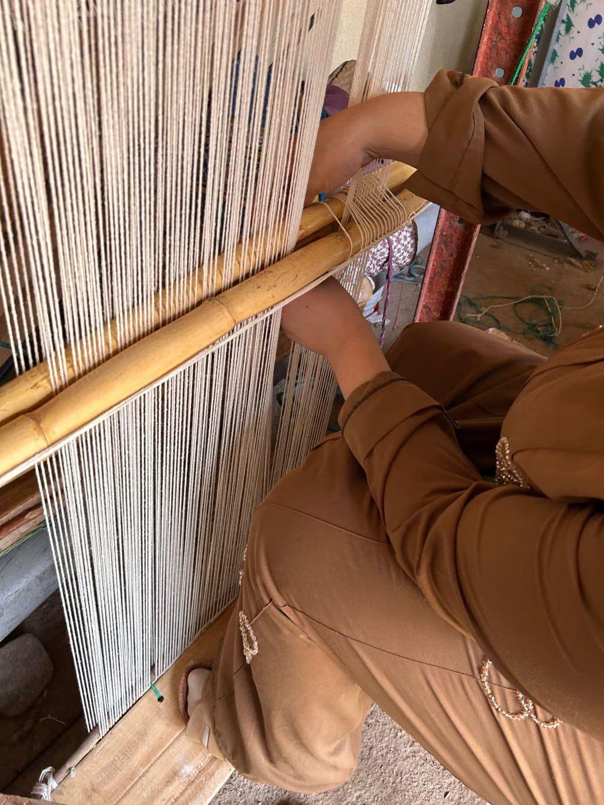 Artisane tissant un tapis berbère sur un métier à tisser vertical